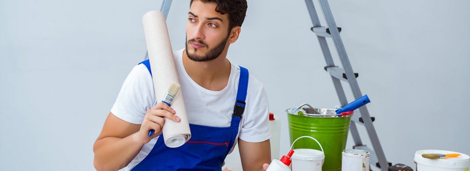 Reparateur bei Renovierungsarbeiten im Haus mit Papiertapete