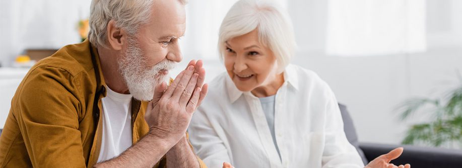 Ein älteres Paar sitzt zusammen und unterhält sich - Wohnwünsche im Alter