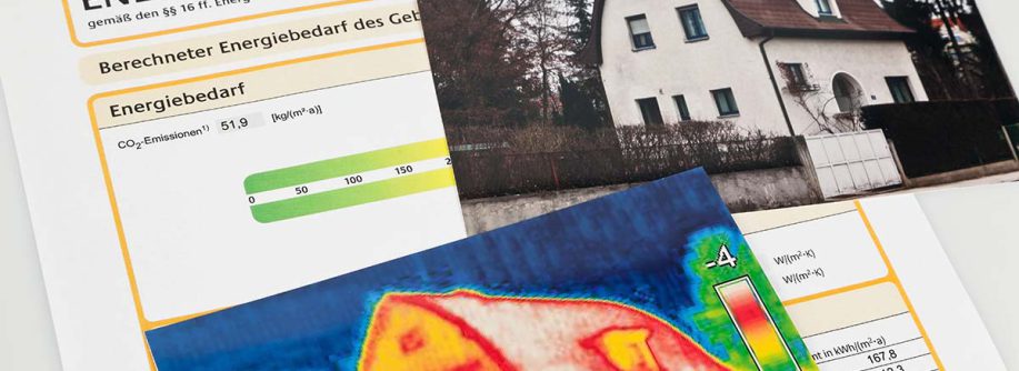 Ein Energieausweis liegt neben zwei Bildern von Häusern. Das eine ist ein realistisches Foto, das andere stellt das Gebäude als Wärmebild dar.