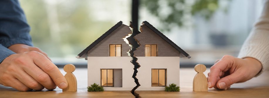 Geteiltes Hausmodell mit zwei Holzfiguren symbolisiert die Aufteilung einer Immobilie bei Trennung ohne Trauschein. I Trennung ohne Trauschein